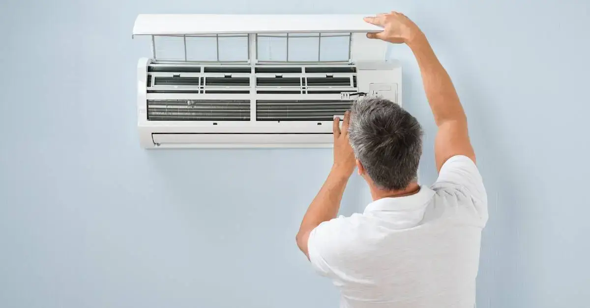 Homeowner checking outdoor AC unit that is not working, troubleshooting common air conditioner problems in Glenpool Oklahoma